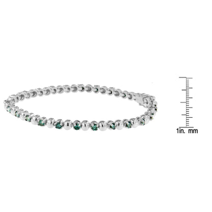 White metal bracelet with round blue gemstones in prong settings, shown in a side angle view on a white background with a ruler for size reference.