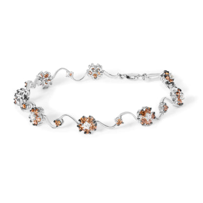 Top-down view of a white metal bracelet with alternating clusters of round white and champagne-colored gemstones in prong settings connected by wavy links.