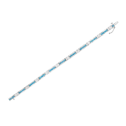 White metal bracelet with alternating princess-shaped white and blue gemstones in a channel setting, shown flat on a white background from a top-down angle.