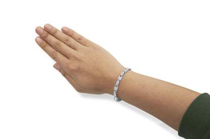 White metal bracelet with alternating rectangular links set with white round and princess shape gemstones, shown on a model's wrist at an angled top-down view.