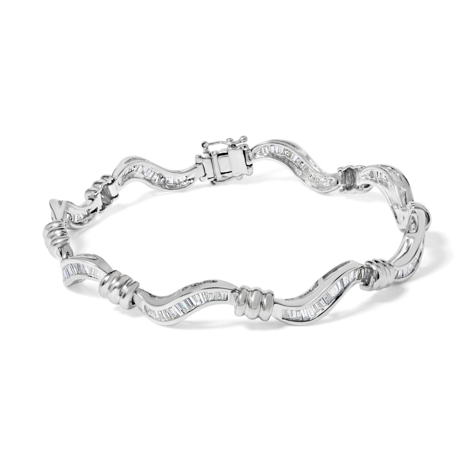 White metal bracelet with a wavy design featuring channel-set baguette-shaped white gemstones, shown from a top angle.