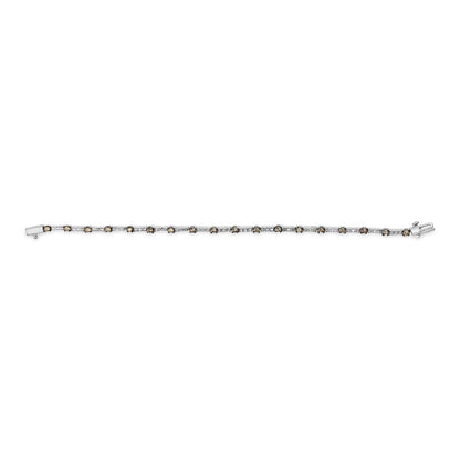 White metal bracelet with alternating round champagne and white gemstones in prong settings, shown from a top flat lay angle.
