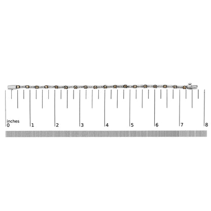 White metal bracelet with alternating white and champagne round gemstones in prong settings, laid flat on a ruler for size reference, top-down view.