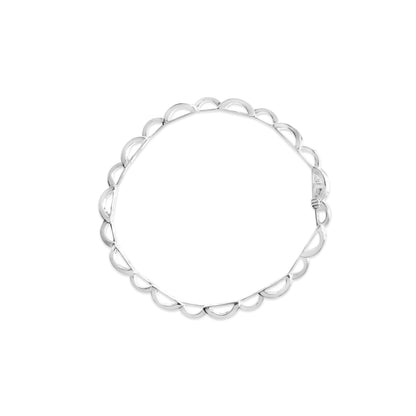 Top-down view of a white metal bracelet with a scalloped edge design featuring princess-shaped white gemstones in an invisible setting.