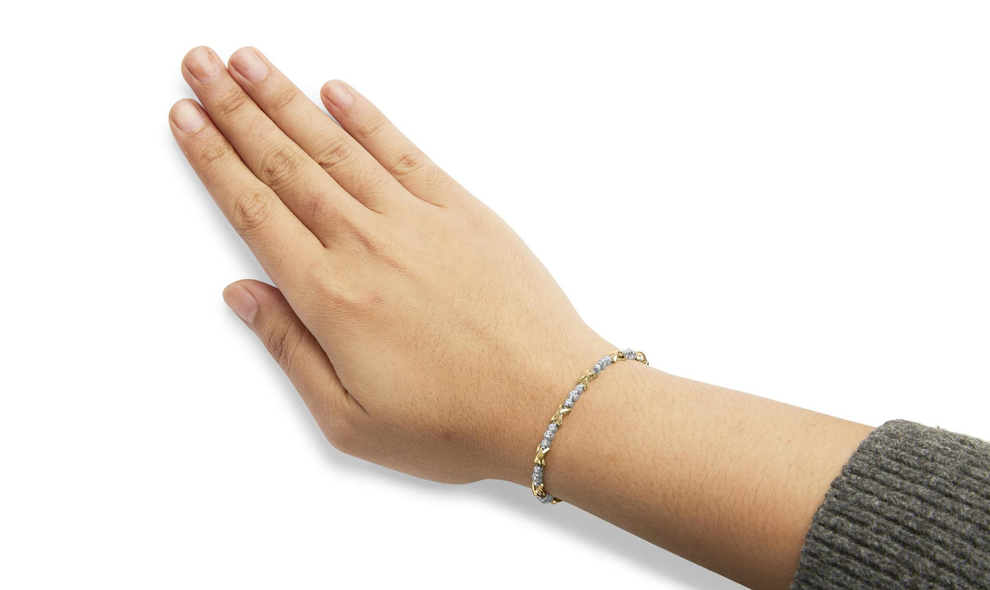 Bracelet with alternating yellow and white metal links and round white gemstones in prong settings, shown on a model’s wrist from an overhead angle.
