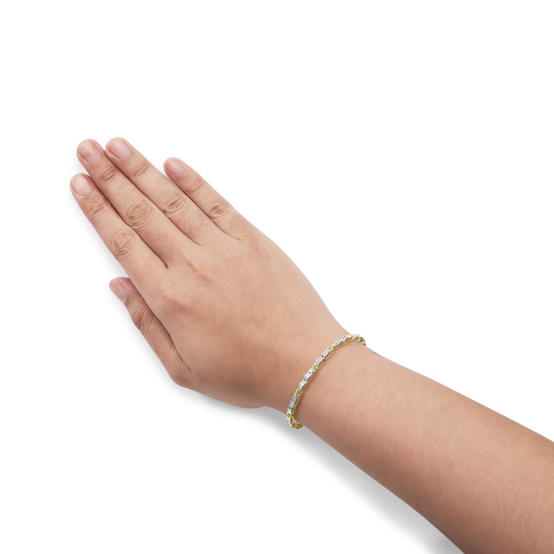 Yellow bracelet with white baguette-shaped gemstones in a channel setting, shown worn on a model's wrist from a top-side angle.