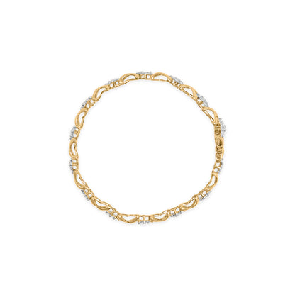 Top-down view of a yellow metal bracelet with alternating open loop links and clusters of small white gemstones in prong settings.