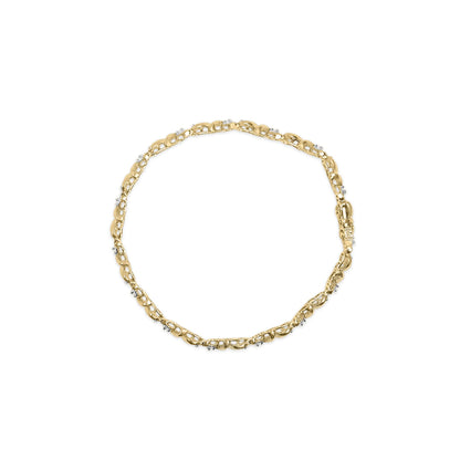 Top-down view of a yellow metal bracelet with round white gemstones set in a miracle setting along the links, displayed on a white background.