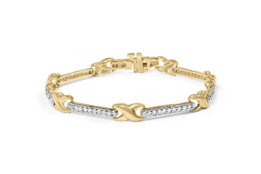 Yellow metal bracelet with sections of white gemstones in prong settings, shown at a slight angle on a white background.