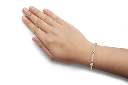 Yellow bracelet with white round gemstones in prong setting, shown on a model's wrist, photographed from the side angle.