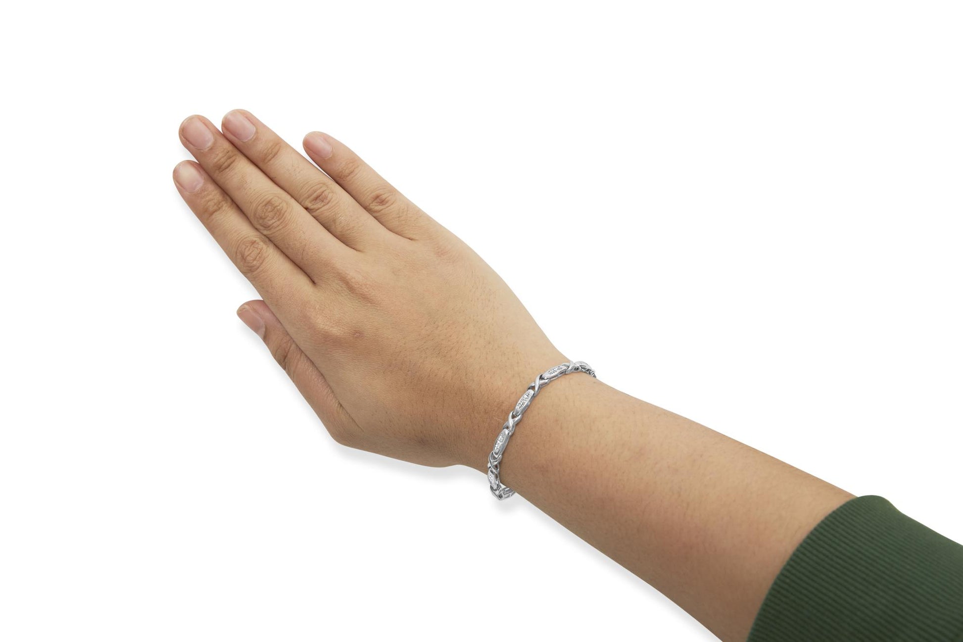 White metal bracelet with white gemstones in an intricate design, shown on a model's wrist from a side angle.