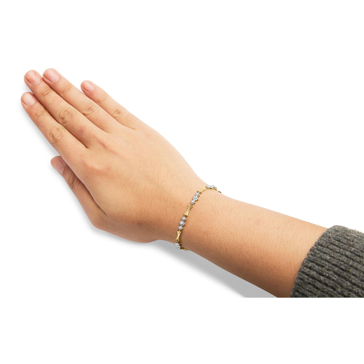Yellow and white metal bracelet with round white gemstones in miracle setting, shown on a model's wrist from side angle.