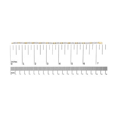 Bracelet with alternating yellow and white metal links featuring white round gemstones in prong settings, displayed flat on a ruler for size reference, shot from above.