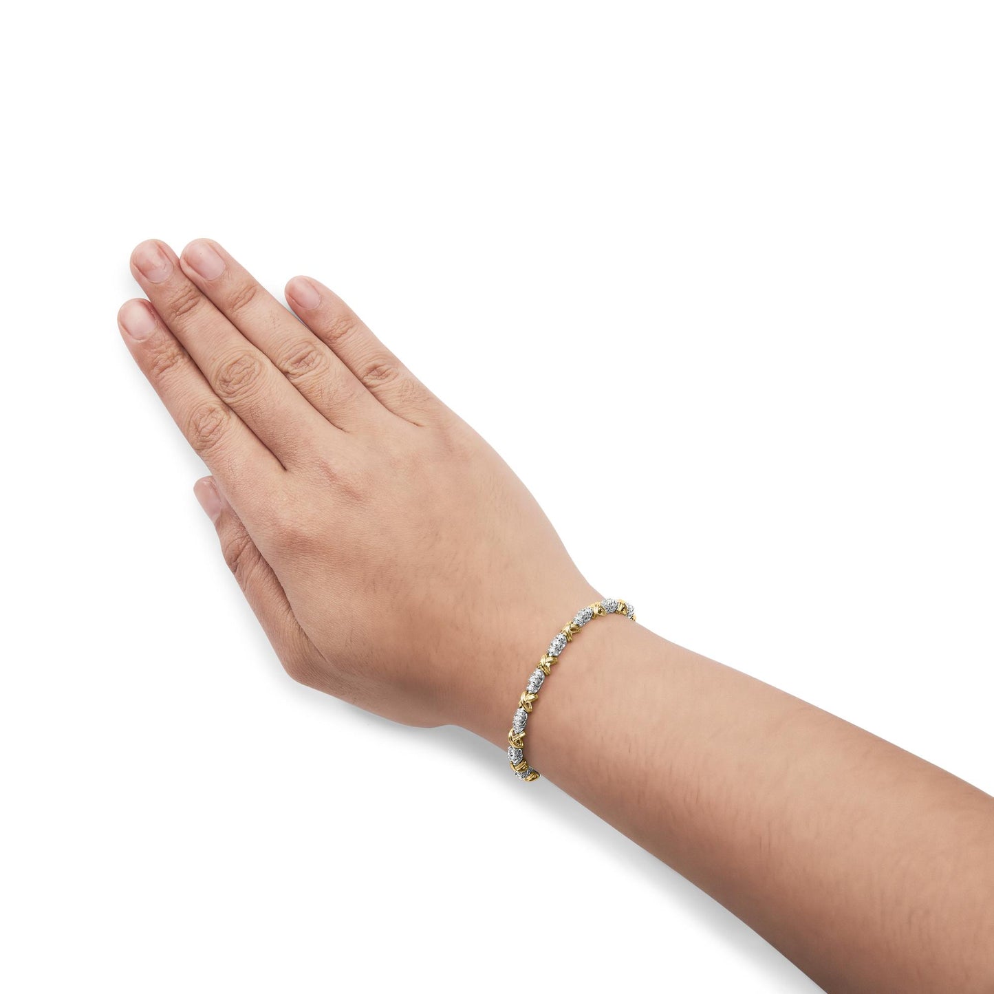Bracelet with alternating yellow and white metal settings, each holding a round white gemstone in a prong setting, shown worn on a model's wrist from a top side angle.