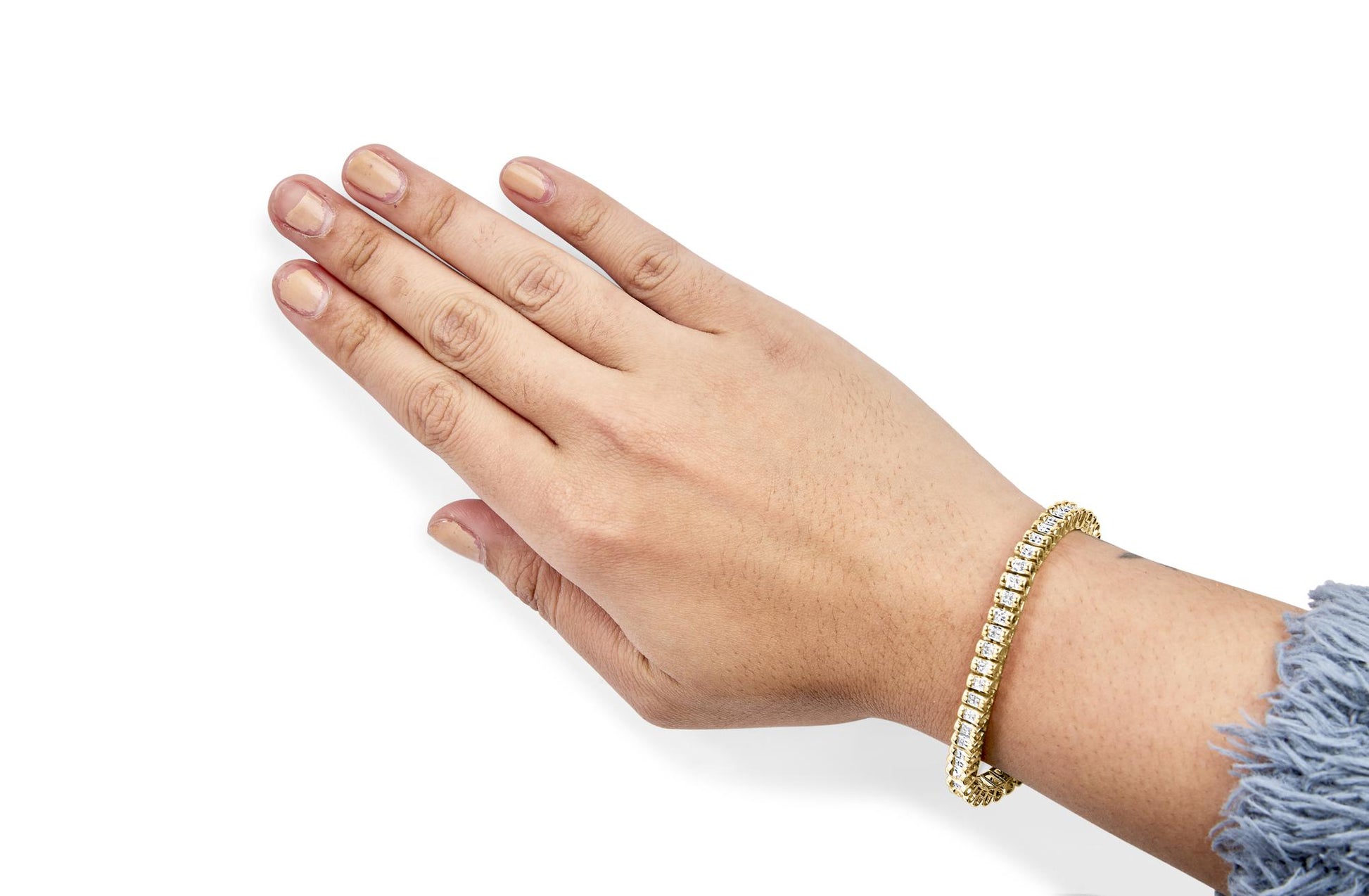 Yellow bracelet with white princess shape gemstones in channel setting, shown on a model's wrist, angled from above.