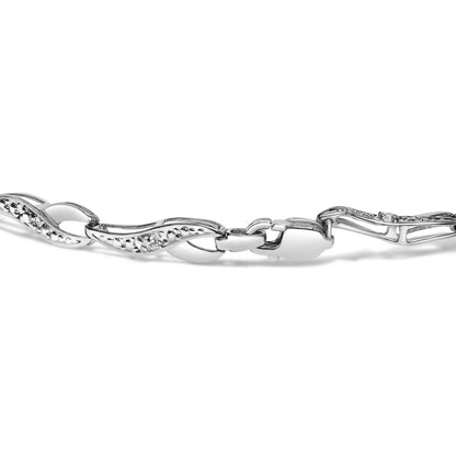 Close-up angle of a white metal bracelet with wavy links, each set with round white gemstones in prong settings, featuring a clasp closure.