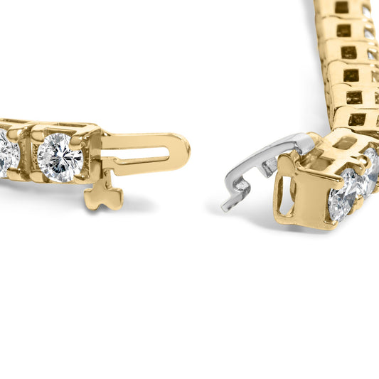 Close-up angled view of a yellow bracelet clasp featuring round white gemstones in prong settings.