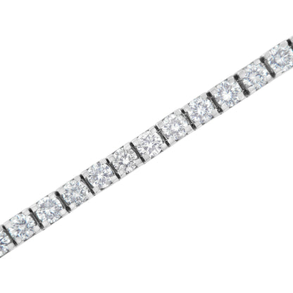 Close-up shot of a white metal bracelet with round white gemstones in prong settings arranged in a continuous line.