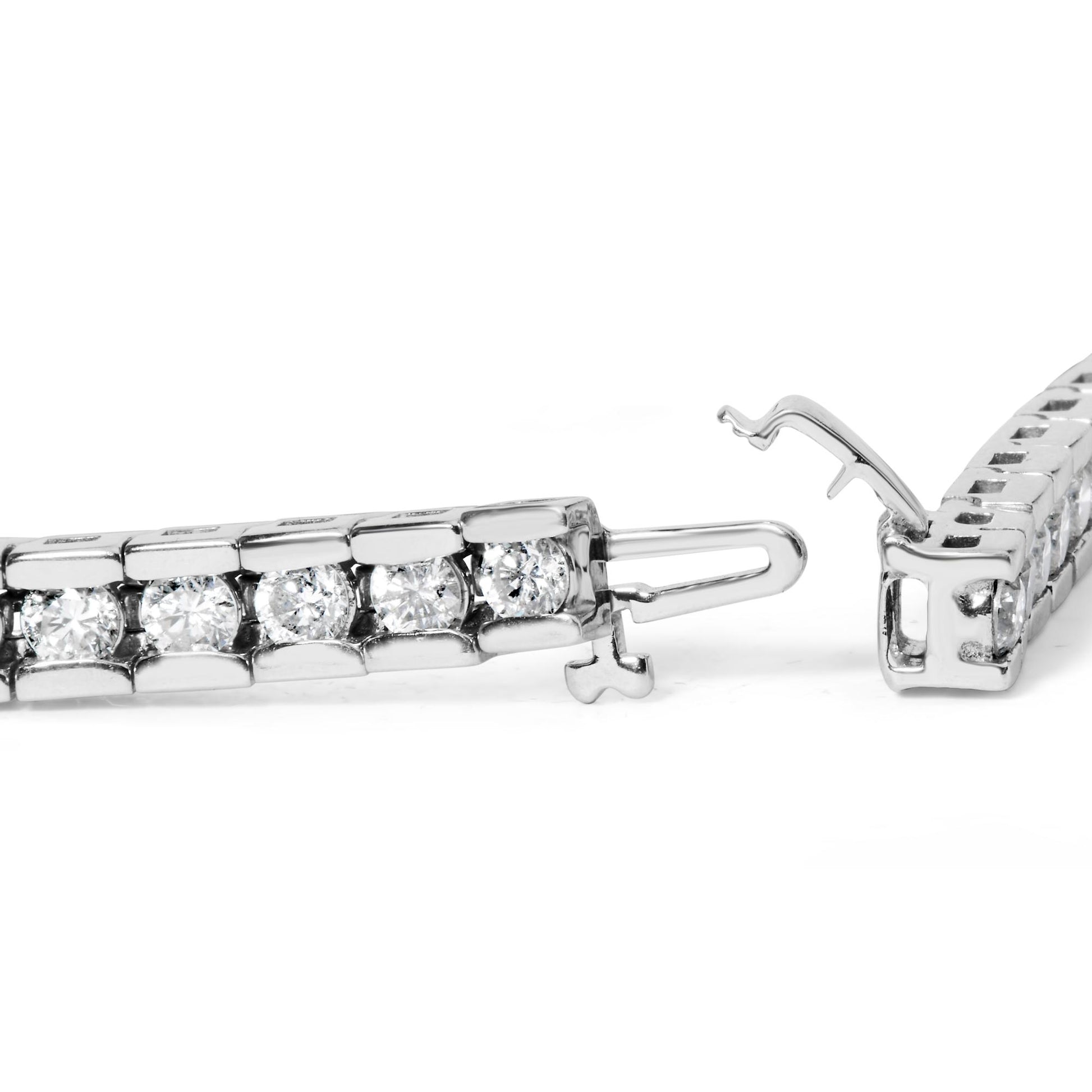 Close-up side angle of a white metal bracelet with round white gemstones in a channel setting, showing the open clasp mechanism.