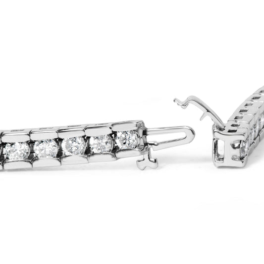 Close-up side angle of a white metal bracelet with round white gemstones in a channel setting, showing the open clasp mechanism.
