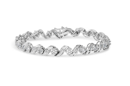 White metal bracelet with twisting design featuring round and baguette white gemstones, shown in a front angled close-up.
