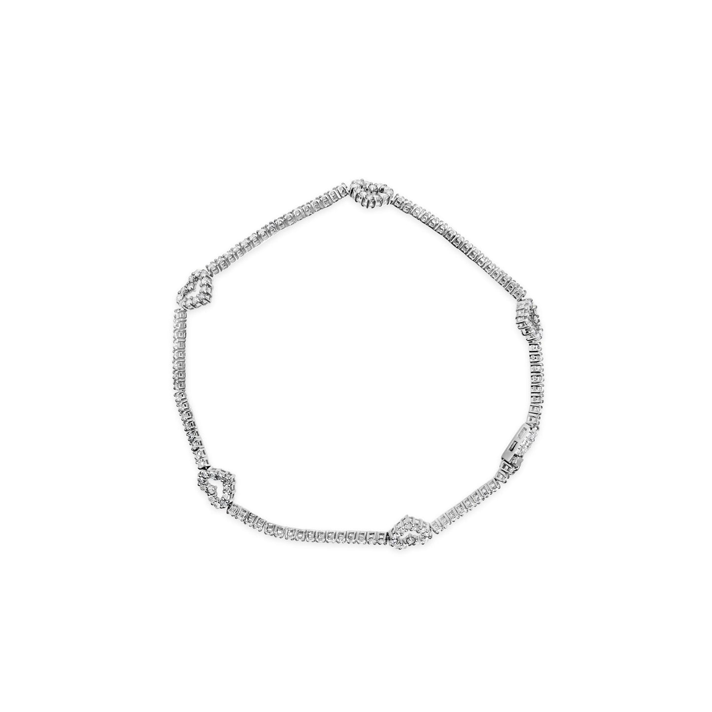 Top-down view of a white metal bracelet with multiple round white gemstones in prong settings, featuring heart-shaped gemstone clusters evenly spaced along the chain.