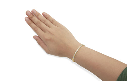 Yellow bracelet with white round pave gemstones, shown on a model's wrist from a top angle.