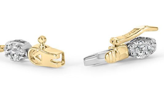 Close-up front angle of a yellow and white metal bracelet clasp featuring clusters of round white gemstones in a prong setting.