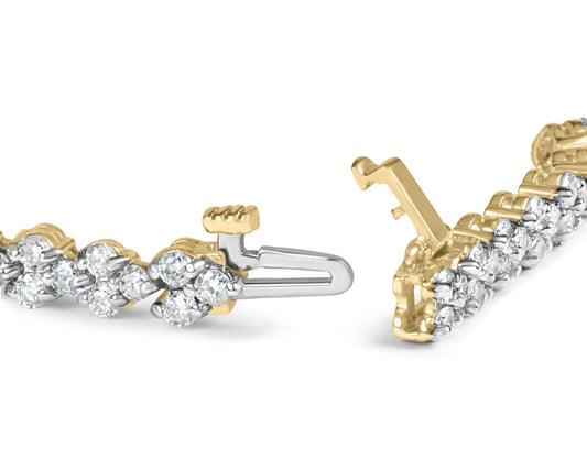 Close-up front angle view of a yellow metal bracelet section featuring round white gemstones in prong settings, showing the clasp mechanism.