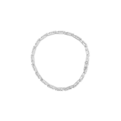 Top-down view of a white metal bracelet set with round and baguette white gemstones in pave and channel settings.
