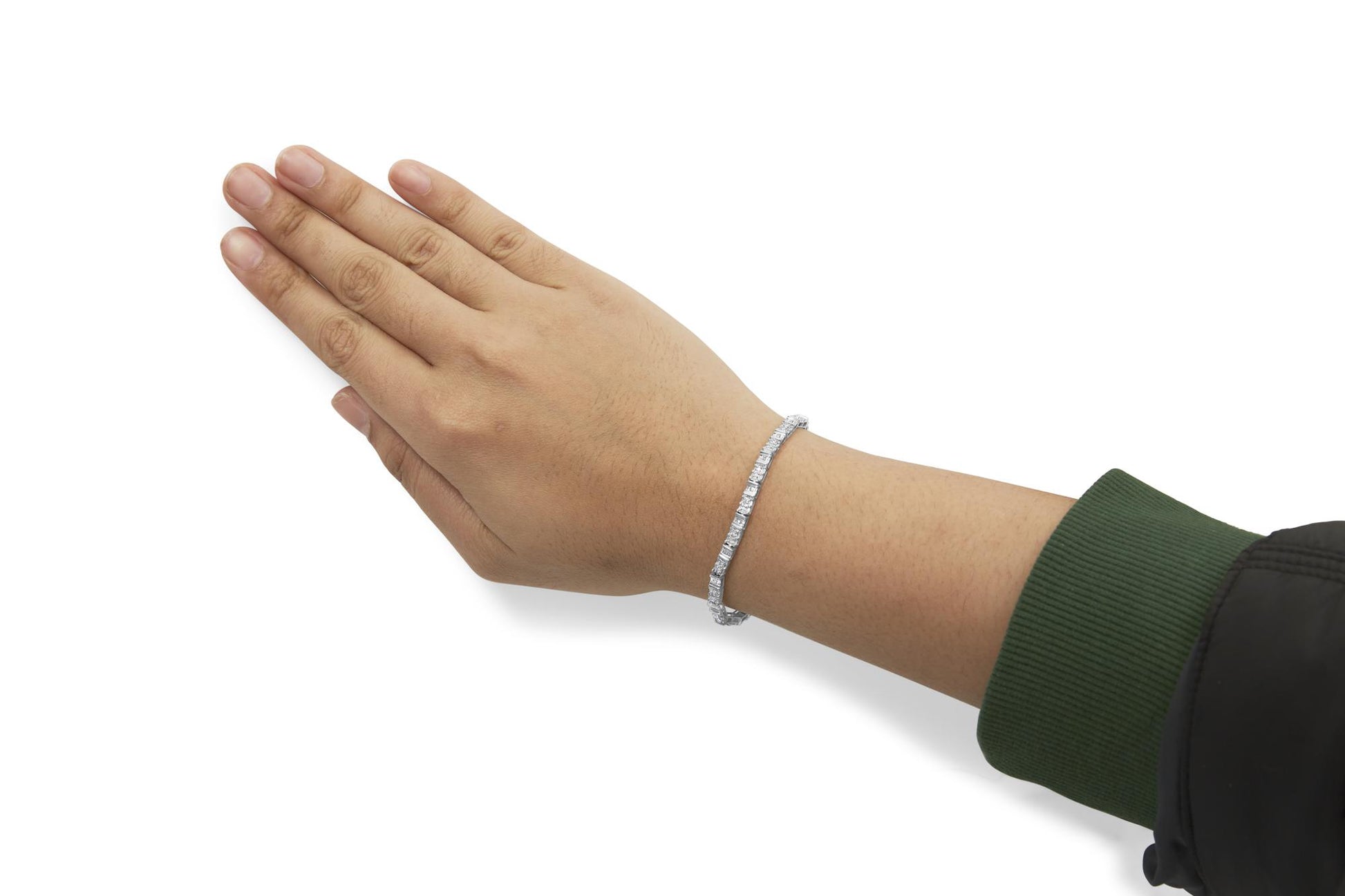 White metal bracelet with round and baguette shaped white gemstones in pave and channel settings, shown on a model's wrist from a side angle.