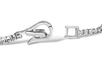 Close-up front angle of a white metal bracelet clasp with round and baguette-shaped white gemstones in prong and channel settings.