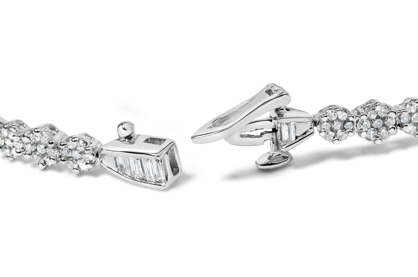 Close-up, angled view of a white metal bracelet with round white gemstones in prong settings and baguette-shaped white gemstones in channel settings, showing the clasp.