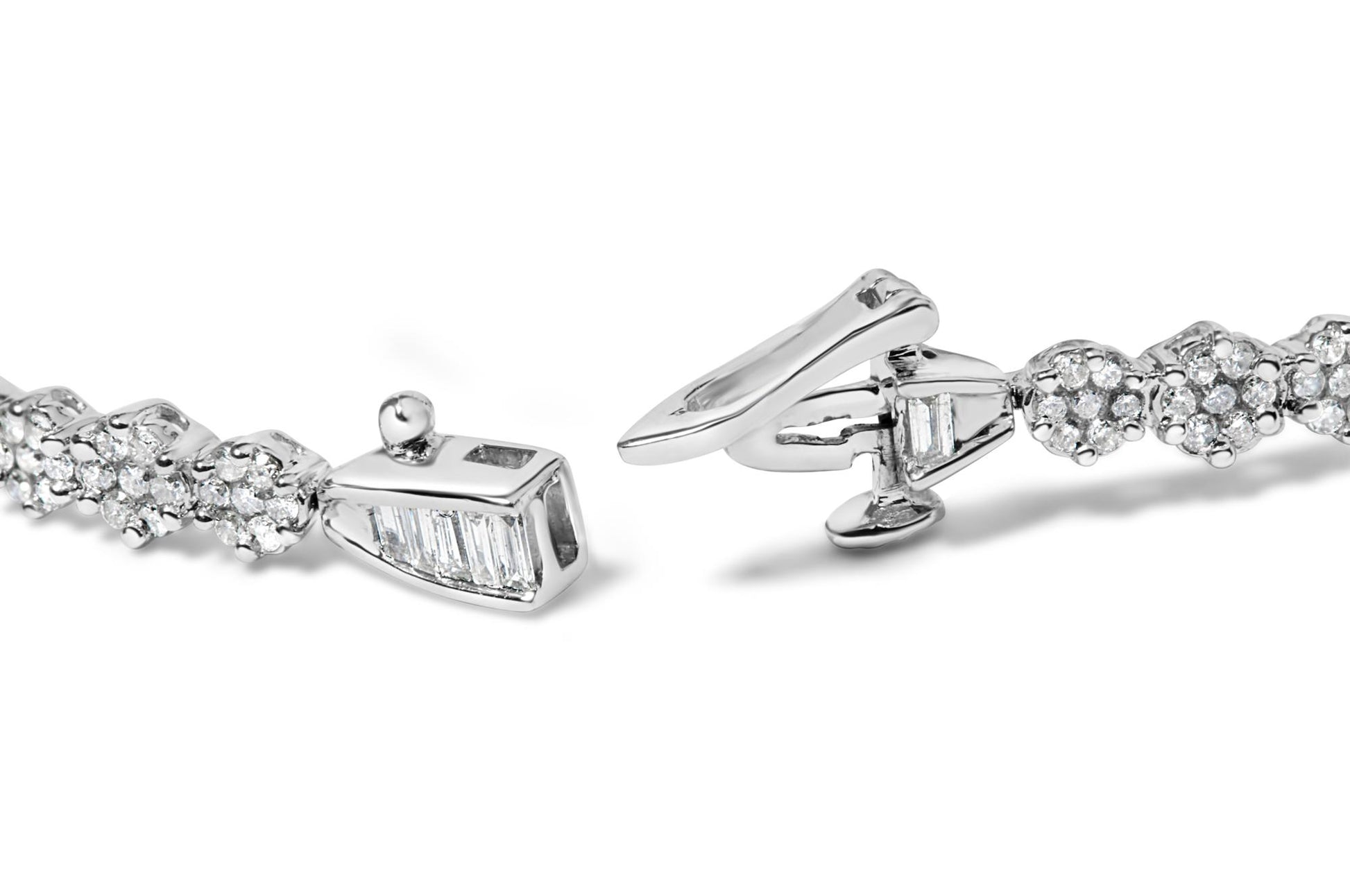 Close-up, angled view of a white metal bracelet with round white gemstones in prong settings and baguette-shaped white gemstones in channel settings, showing the clasp.