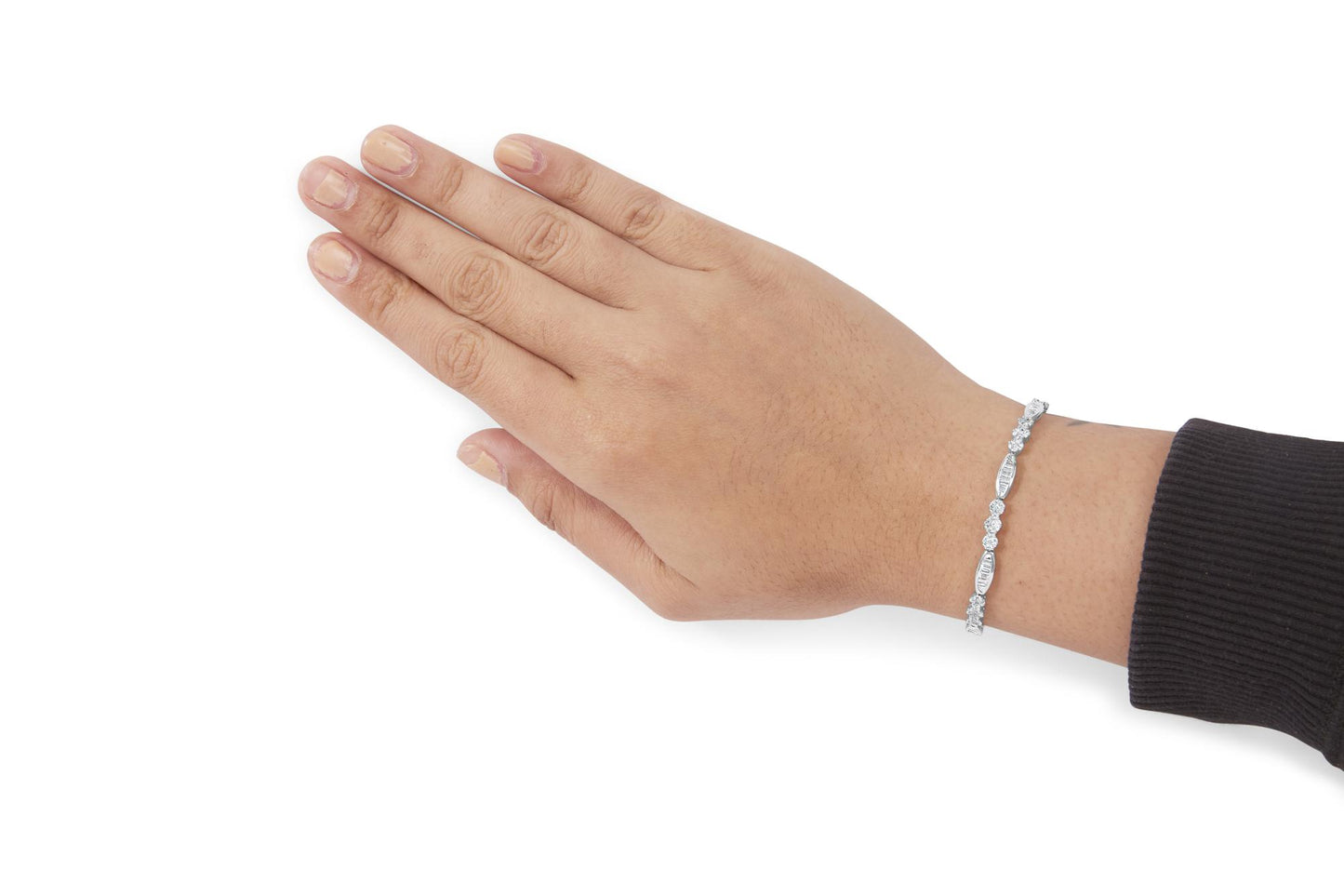 White metal bracelet with alternating baguette and round white gemstones, worn on a model's wrist, shown from the top angle.