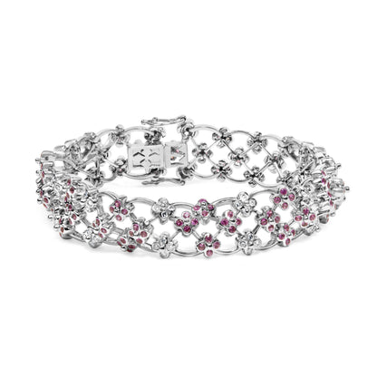White metal bracelet with an intricate openwork design featuring clusters of round pink and white gemstones in bezel settings, shown in a front angle view.