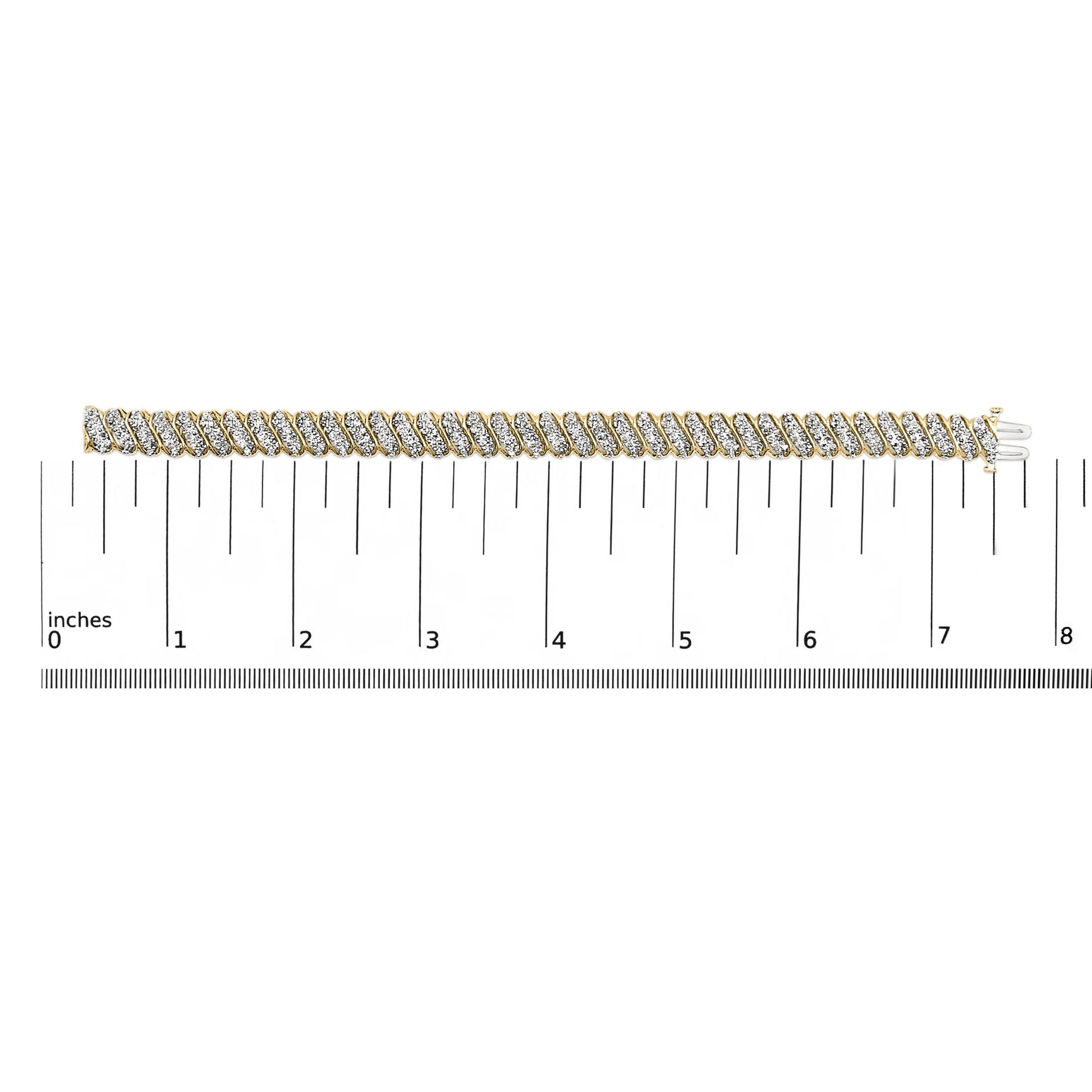 Close-up shot of a yellow metal bracelet with diagonal rows of white round gemstones in prong settings, shown laid flat on a measurement scale.