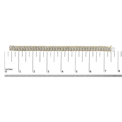Close-up shot of a yellow metal bracelet with diagonal rows of white round gemstones in prong settings, shown laid flat on a measurement scale.