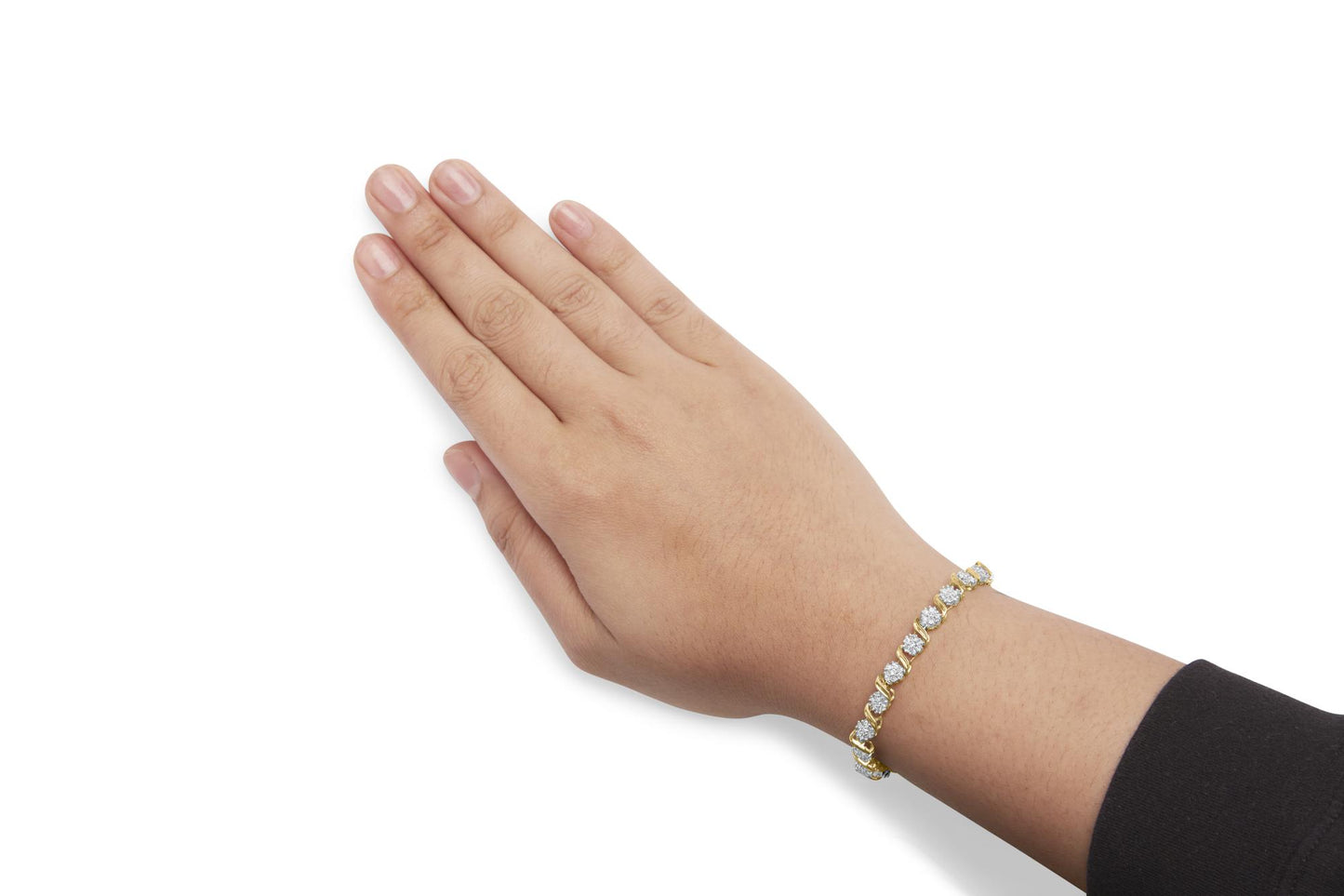 Close-up angled view of a yellow metal bracelet with round white gemstones in prong settings, worn on a model's wrist.