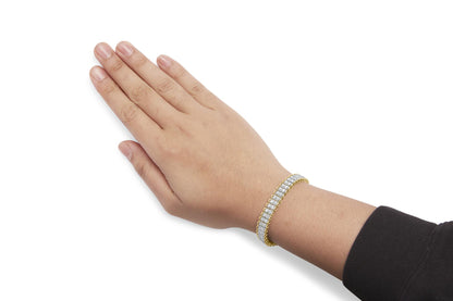 Yellow metal bracelet with two rows of white round gemstone prong settings, worn on a model's wrist, shot from side angle.