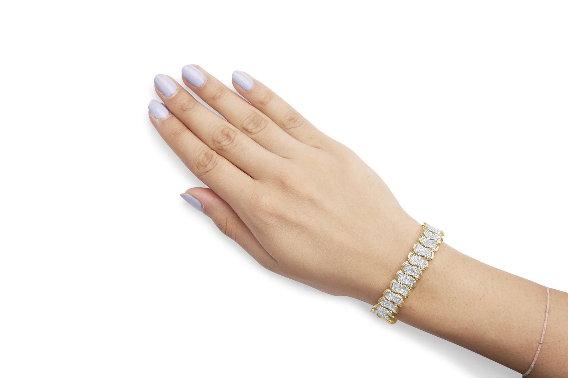 Close-up side angle of a yellow metal bracelet with multiple sections set with white round gemstones in prong settings, worn on a model's wrist.