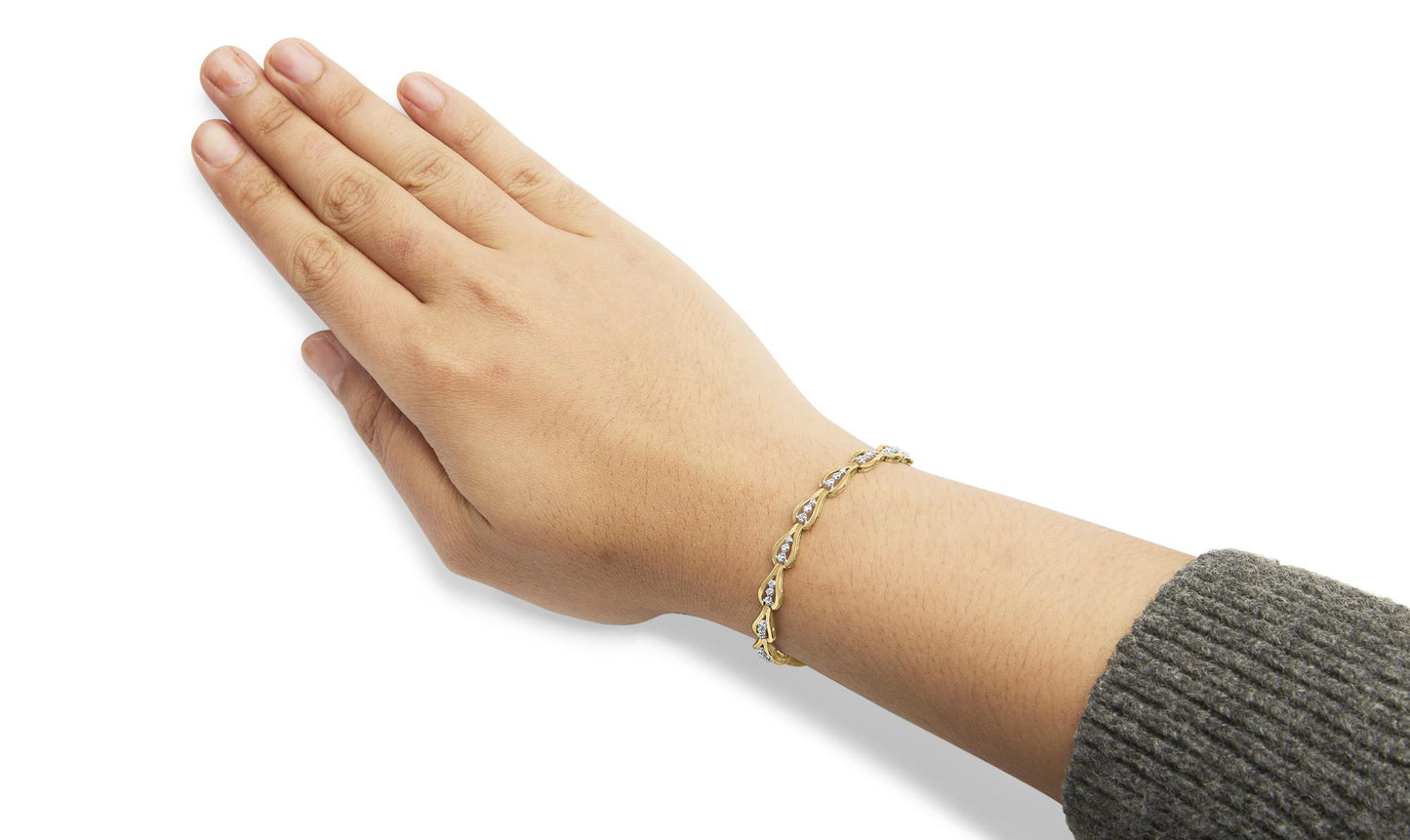 Yellow metal bracelet with prong-set white round gemstones shown on a model's wrist, side angle.