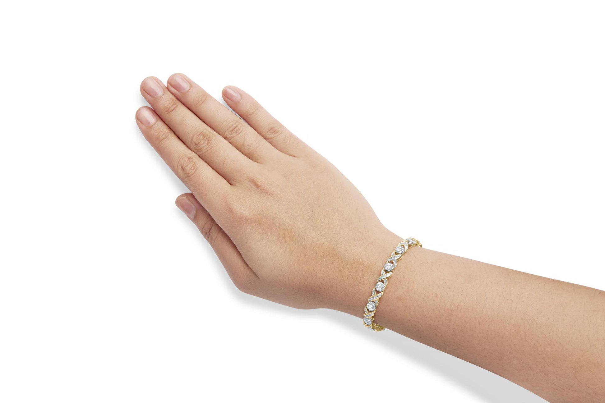 Yellow metal bracelet with round and baguette white gemstones, prong and channel settings, shown on a model's wrist from a side angle.