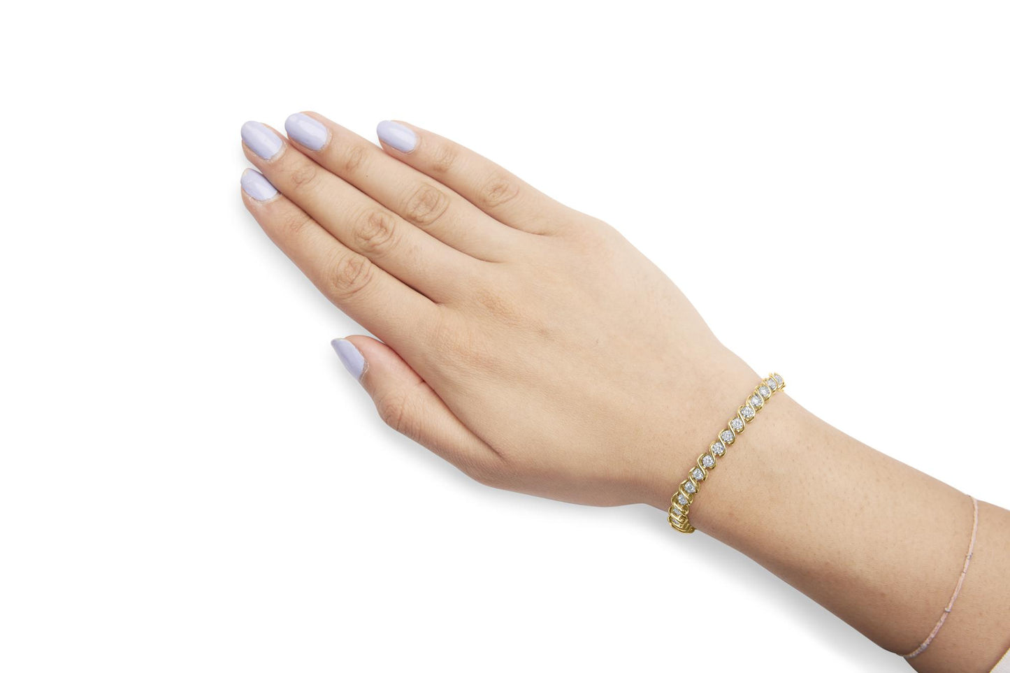 Close-up angled shot of a model's wrist wearing a yellow metal bracelet set with round white gemstones in a miracle setting.