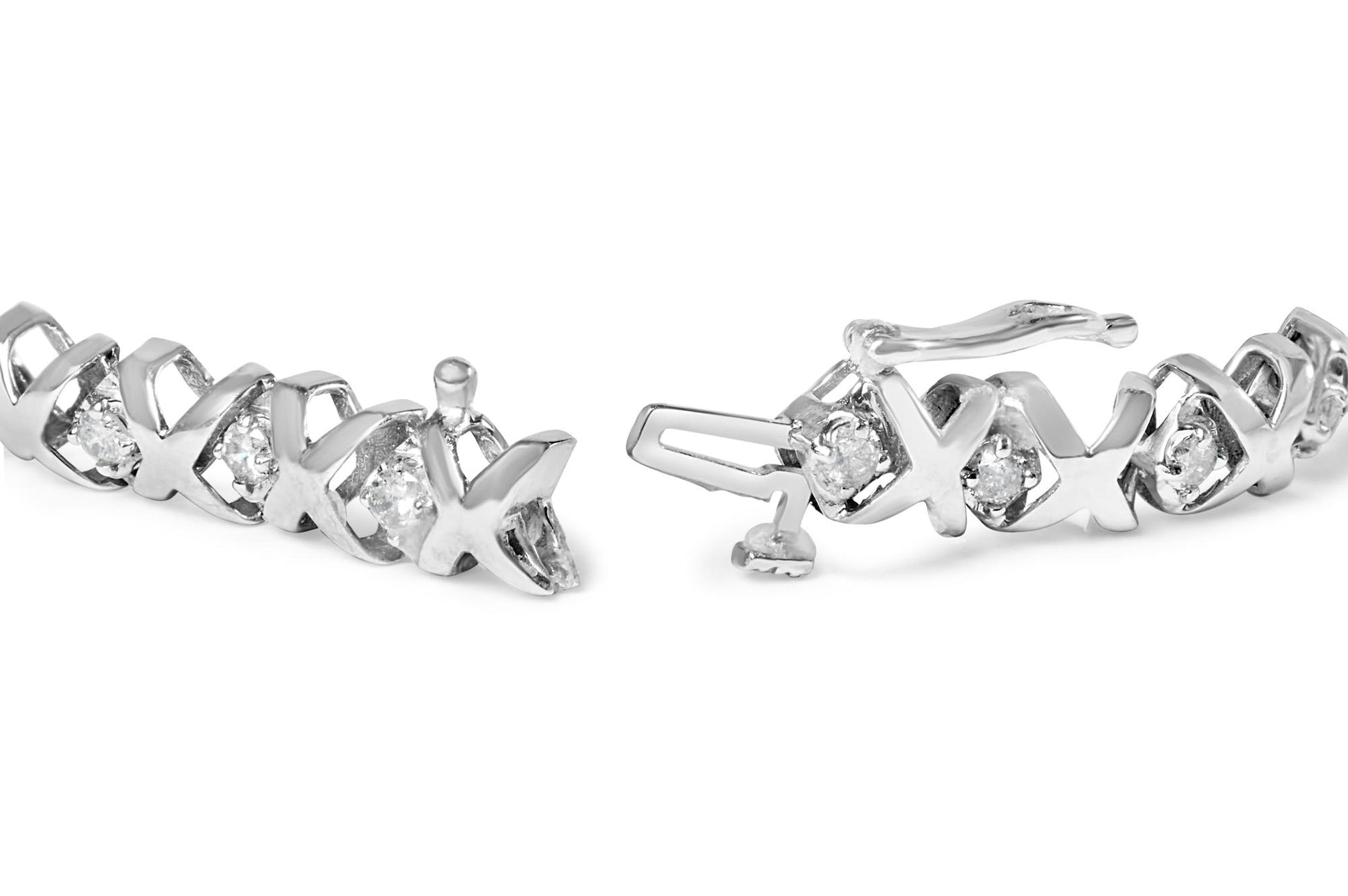 Close-up of a white bracelet with alternating X-shaped links and round white gemstones in prong settings, shown from a front angle.