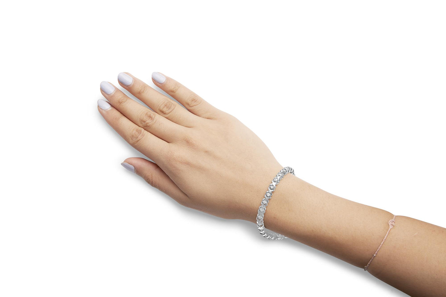 White metal bracelet with prong-set round white gemstones, worn on a model's wrist, shown at an angled top-down view.