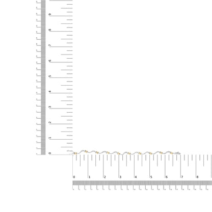 Bracelet with alternating yellow and white metal links set with round white gemstones, displayed flat on a ruler for size reference, shot from above.