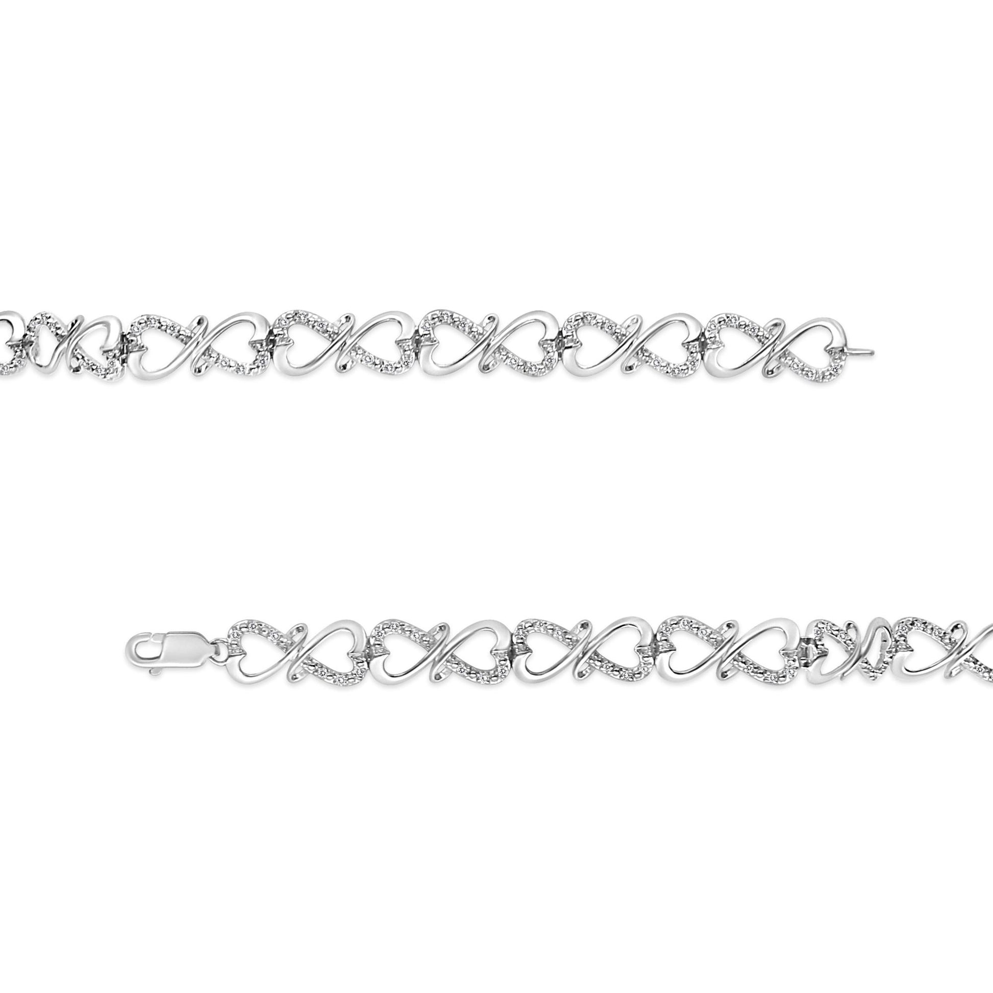 White metal bracelet with alternating heart and infinity-shaped links adorned with white round gemstones, shown in a flat lay top-down view.
