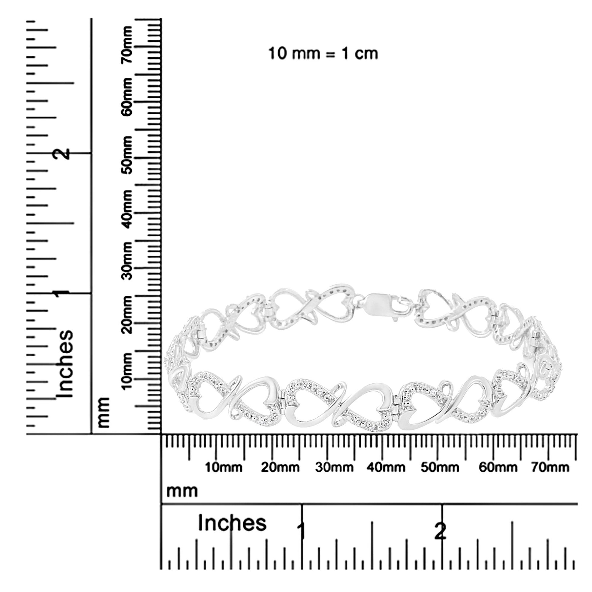 White metal bracelet with alternating heart and infinity link design, accented with round white gemstones, displayed flat on a ruler for size reference, front-facing angle.