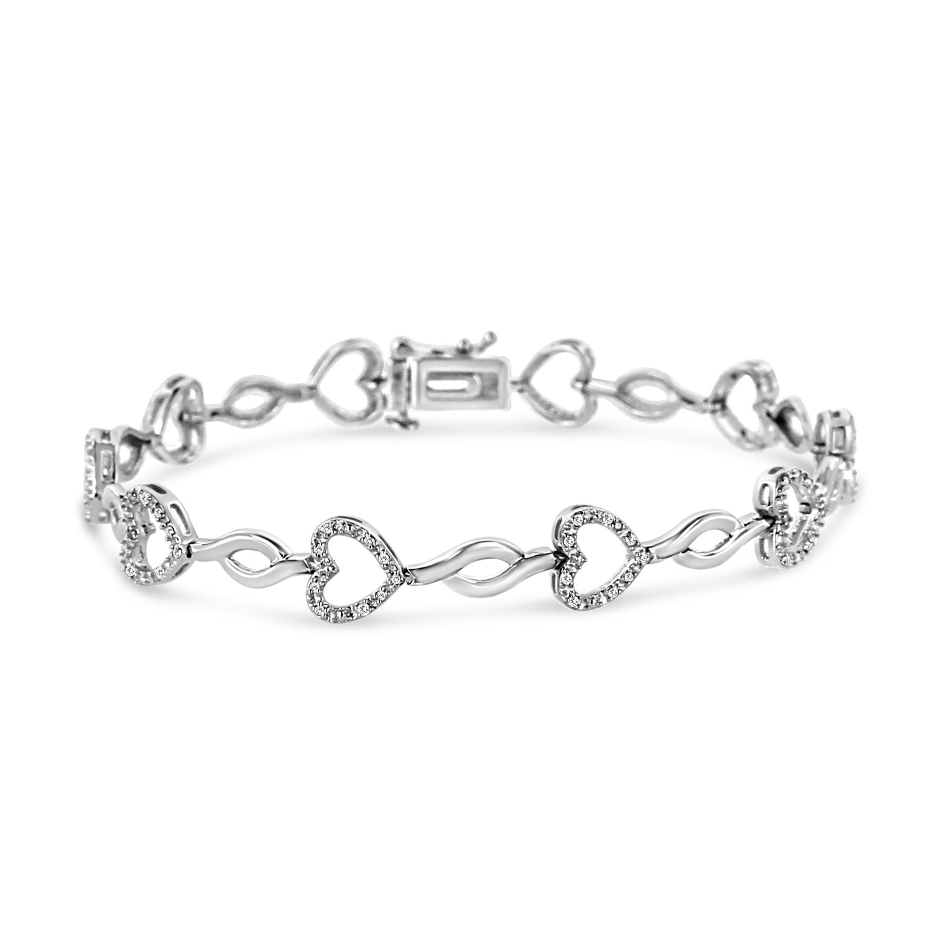 White metal bracelet with heart-shaped links adorned with white round gemstones in prong settings, shown in a slightly angled close-up view.